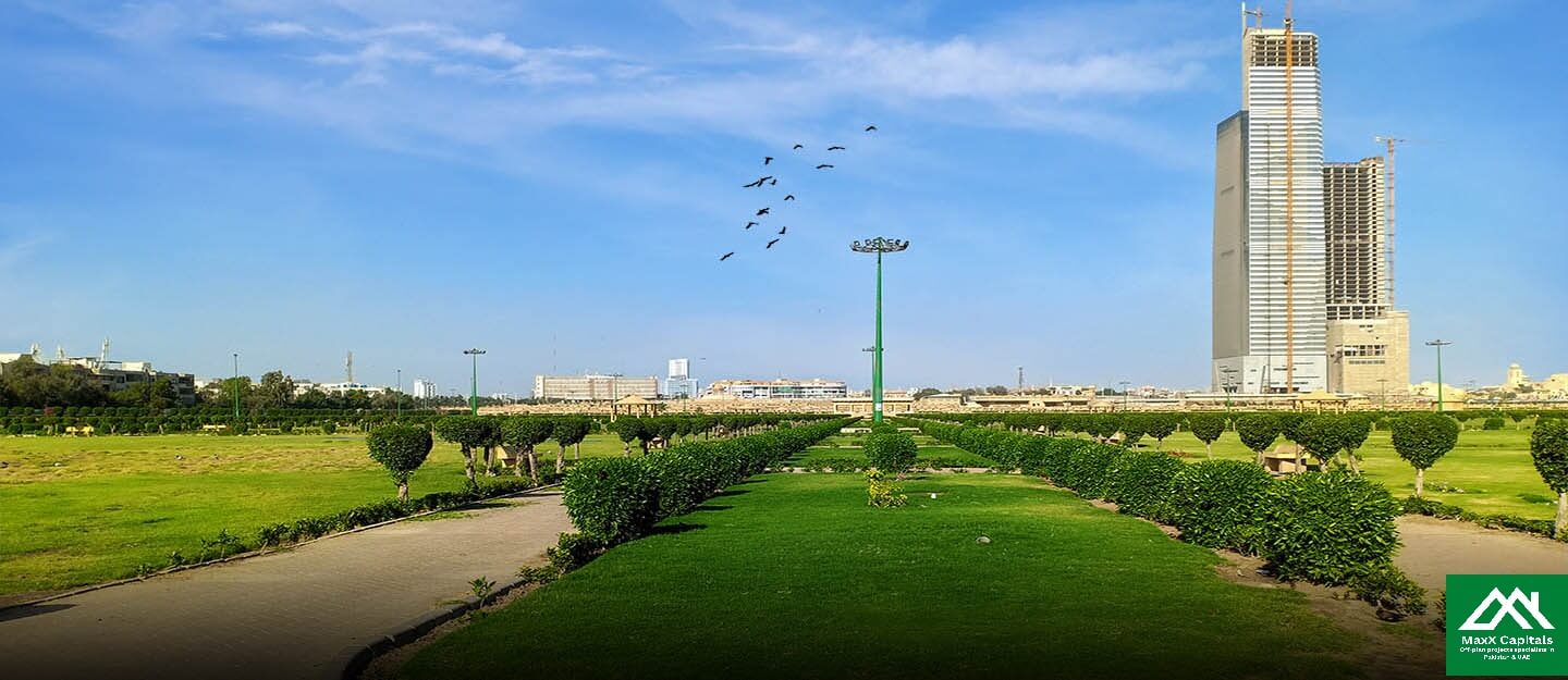 Lush green urban park with manicured lawns, hedges, palm trees, pathway, tall skyscraper, birds flying in blue sky